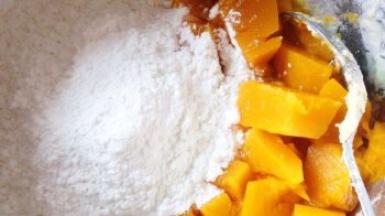 晾凉后的南瓜倒入糯米粉开始和面。蒸熟后的南瓜自带水分，所以无需加水。