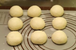 将面团轻拍排气后平均分成9份，大概一个在50克左右，室温盖保鲜膜松弛20分钟