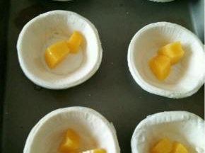 拿出蛋挞皮，放入适量黄桃粒。