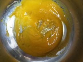 镜面材料中的60克芒果泥加入半片吉利丁片，小火加热至吉利丁片完全溶化。