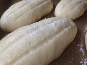 面包坯发酵好后取出，割三道口子，在表面喷点水，撒上粗砂糖