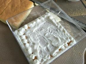 取一片蛋糕片，涂一层奶油，再挤一层豆乳，筛上熟的黄豆粉。