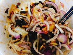 将香菇丝和洋葱丝放入腌个鸡的剩余汁料中充分混合。