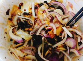 将香菇丝和洋葱丝放入腌个鸡的剩余汁料中充分混合。