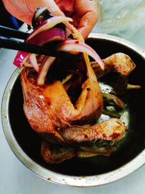 将混合好的香菇丝和洋葱丝， 姜， 蒜等其他调料塞入鸡腹中；