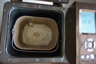 倒入面粉，在面粉顶端加入酵母，面包桶放入到东菱1352AE-3C面包机里，选择和面10分钟