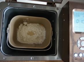 倒入面粉，在面粉顶端加入酵母，面包桶放入到东菱1352AE-3C面包机里，选择和面10分钟