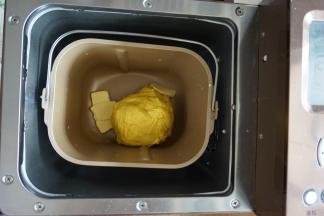 在第一次和面结束后，加入切成小块的黄油，选择和面12分钟