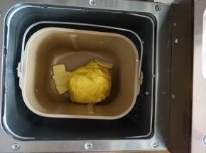 在第一次和面结束后，加入切成小块的黄油，选择和面12分钟