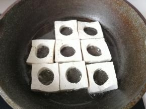 锅中倒入适量油，把刻好的豆腐块放入锅中。