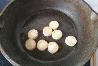 再把小圆片豆腐也放入锅中煎至两面金黄，煎好后也盛起备用。