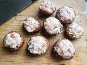 用手挤一个肉丸子大的肉馅放到香菇上。