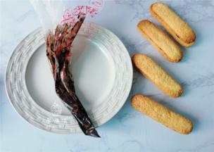 取适量的巧克力装入裱花带里融化，再挤入晾晾会的饼干上，两片合起来