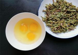 把香椿拧干水分切丁，鸡蛋磕入碗中备用