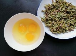 把香椿拧干水分切丁，鸡蛋磕入碗中备用