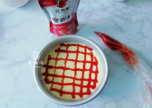 取一个裱花袋子挤入适量的番茄沙司，用裱花袋在蛋糕糊上画出网格即可