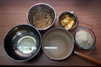 准备制作牛轧糖的所有食材，将白色麦芽糖、清水、细砂糖放入不粘牛奶锅中。