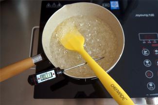 大火将牛奶锅中的混合物煮沸腾后，转中火，边煮边搅拌，煮至糖浆温度超过110度后将蛋清打发至硬性备用。