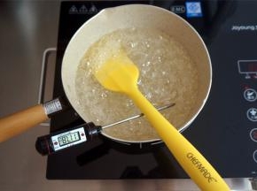 大火将牛奶锅中的混合物煮沸腾后，转中火，边煮边搅拌，煮至糖浆温度超过110度后将蛋清打发至硬性备用。