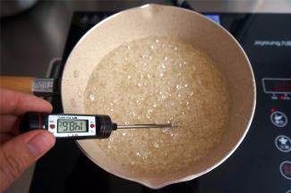 继续中小火熬制糖浆，夏天制作牛轧糖，糖浆温度建议熬至150度左右，测量温度时要将糖浆搅拌均匀，测出来的温度才稳定且准确。