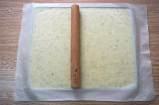 将牛轧糖放入kitty不粘烤盘，隔着不粘油布，用木棒将其擀开，这个配方的分量刚好满模。将做好的牛轧糖放在阴凉处自然冷却，或者放入冰箱直接冷冻降温也可以，我喜欢后者，快捷。