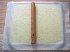 将牛轧糖放入kitty不粘烤盘，隔着不粘油布，用木棒将其擀开，这个配方的分量刚好满模。将做好的牛轧糖放在阴凉处自然冷却，或者放入冰箱直接冷冻降温也可以，我喜欢后者，快捷。