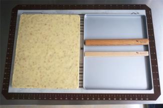 将冷却后的牛轧糖倒扣脱模，脱模时可以借助抹刀挑起一角，然后整块糖掀起即可。