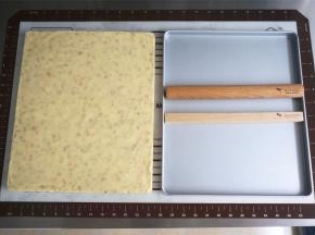 将冷却后的牛轧糖倒扣脱模，脱模时可以借助抹刀挑起一角，然后整块糖掀起即可。