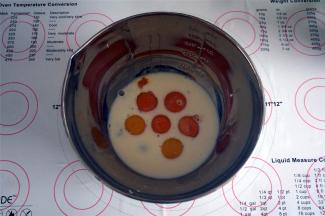 将5个蛋黄，1个全蛋，以及80克牛奶，0.5小茶匙的盐放入到同一个大容器里，搅拌均匀。