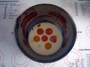 将5个蛋黄，1个全蛋，以及80克牛奶，0.5小茶匙的盐放入到同一个大容器里，搅拌均匀。