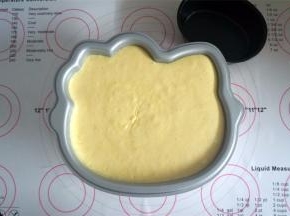 将蛋糕糊倒入8寸的kitty模具中，震荡出大气泡。