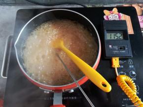 大火加热熬糖，糖浆熬出焦糖色，熬到115度关火