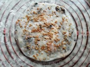 在烧饼上撒上适量的白芝麻，刷一层薄薄的玉米油