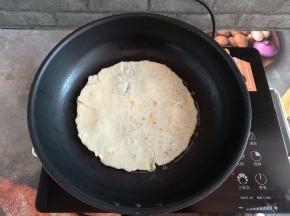 面饼煎到鼓起小泡泡，翻面煎一下，煎好的面饼用保鲜膜或者湿毛巾盖一下，防止变硬