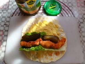 在面饼上放上生菜，酸黄瓜和鸡胸肉