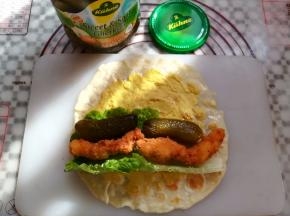 在面饼上放上生菜，酸黄瓜和鸡胸肉