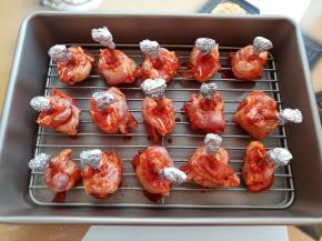 把腌好的鸡锤放到学厨带晾网的深盘里，每个鸡锤骨头上都包上锡纸