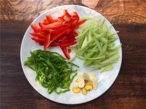 将青椒、甜椒和西芹切丝，大蒜、生姜切片。