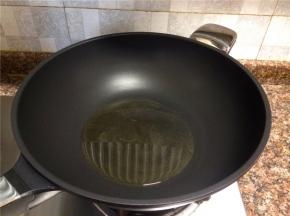 热锅倒油烧至八成热。