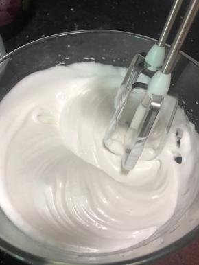 蛋白霜打发有纹路时，将剩下的细砂糖加入进去，中速打发蛋白霜。