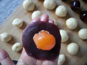 取一个豆沙馅，包裹住蛋黄。