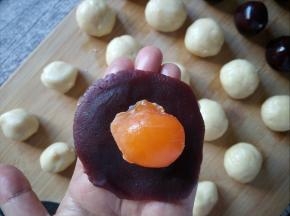 取一个豆沙馅，包裹住蛋黄。