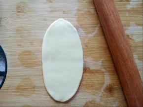 醒好的面团，用擀面杖擀成长舌状。