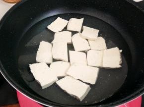 把豆腐切成片，冷水下锅，小火慢煮几分钟，去除它的豆腥味，捞出来放凉。