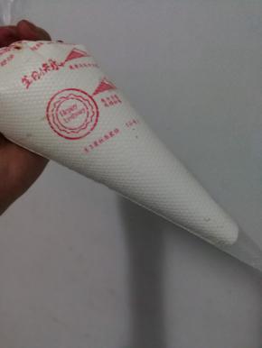 奶油装入裱花袋中，裱花袋剪圆口