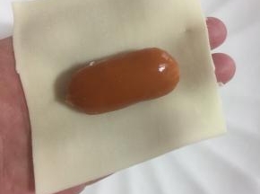 取一张饺子皮，把小脆皮肠放在中间。