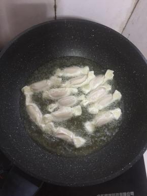 把包好的糖果放进油锅里面中火炸。