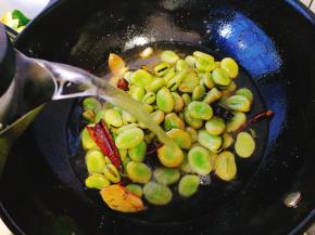 注入开水，没过蚕豆，小火煮约10分钟即可，关火后不揭开盖子焖一会让蚕豆更好的入味，继续在锅内浸泡半小时左右，捞出装盘即可。

