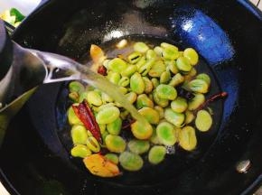 注入开水，没过蚕豆，小火煮约10分钟即可，关火后不揭开盖子焖一会让蚕豆更好的入味，继续在锅内浸泡半小时左右，捞出装盘即可。

