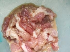 放入料酒和半勺生抽，嫩肉粉腌制十分钟左右。